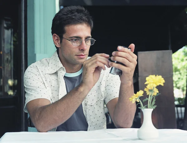 Hispanic man using electronic organizer at outdoor cafe