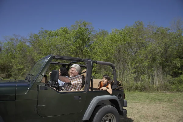 Hispanic family riding in jeep