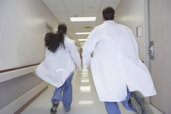 Doctors running down corridor in hospital