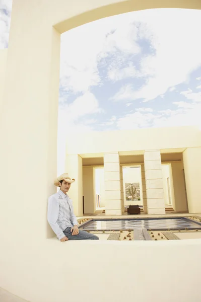 Man sitting next to luxury hotel pool