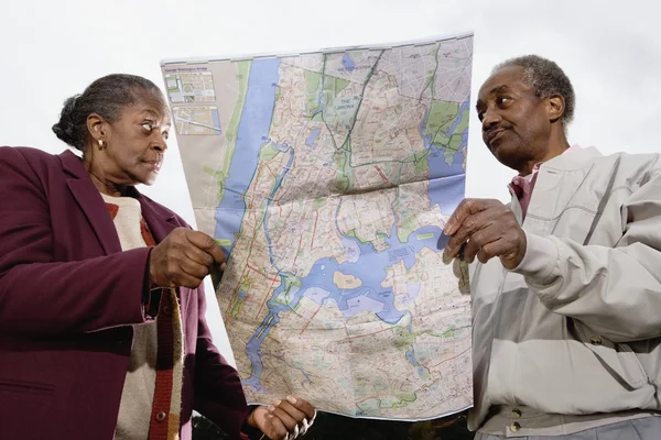 Senior African couple holding map