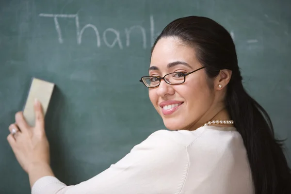 Female teacher erasing chalkboard