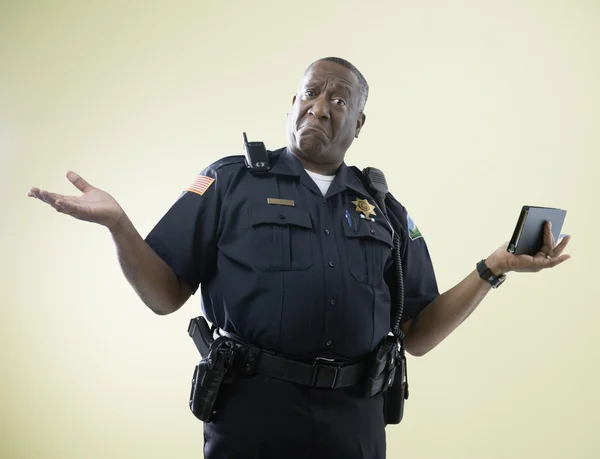 African American male police officer shrugging shoulders
