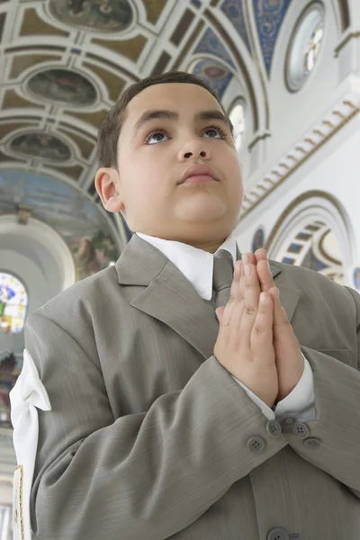 Hispanic boy praying in church