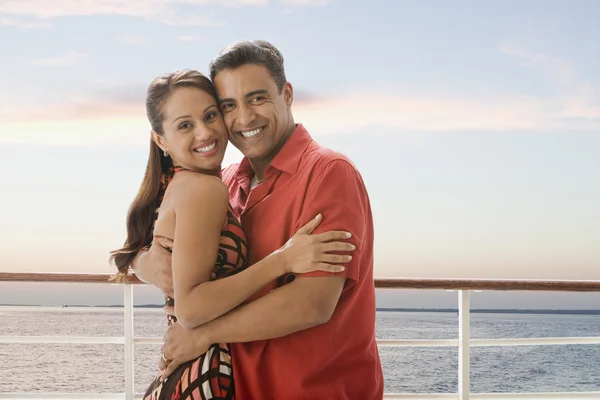 Hispanic couple hugging on ship