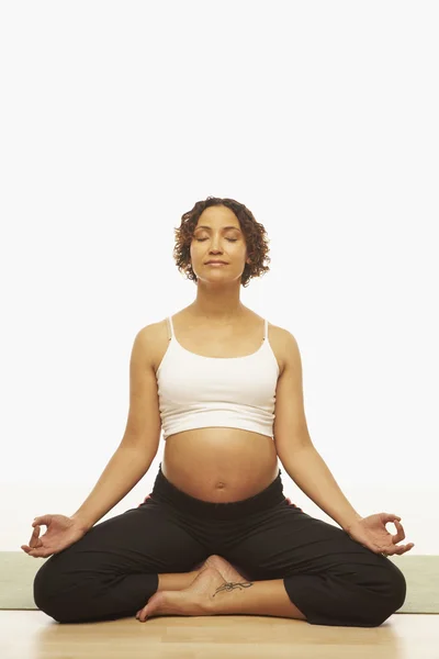 Pregnant Mixed Race woman meditating