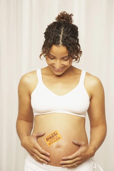 Woman with fragile sticker on belly