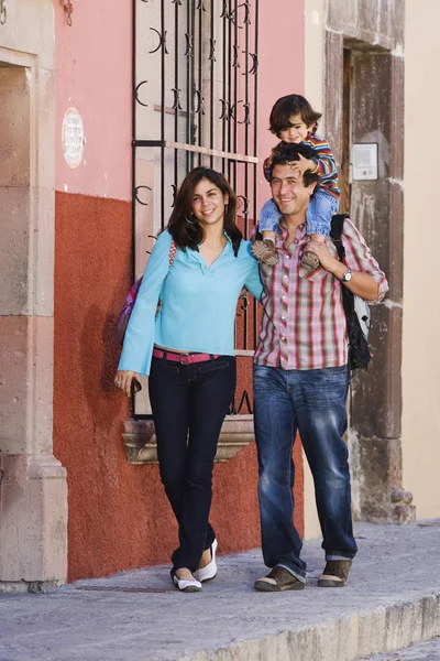 Hispanic family walking on sidewalk