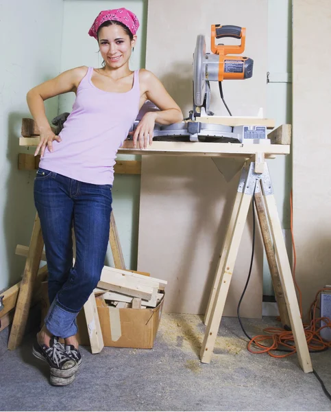 Middle Eastern woman next to table saw