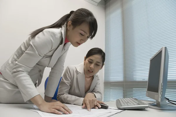 Asian businesswomen looking at paperwork