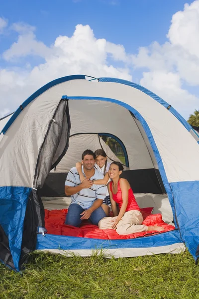 Hispanic family sitting in tent
