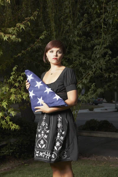 Woman holding folded American flag
