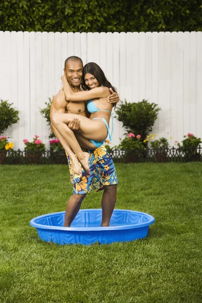 Multi-ethnic couple standing in kiddie pool