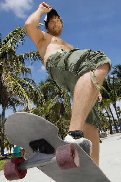 Hispanic man riding skateboard
