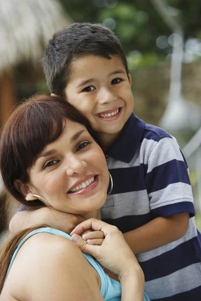 Hispanic mother and son hugging
