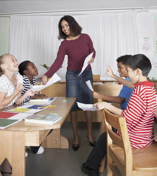 Indian female teacher handing back papers