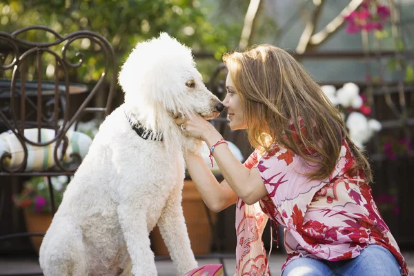Hispanic woman rubbing noses with dog