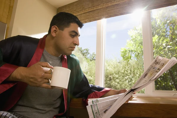 Hispanic man reading newspaper