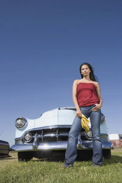 Mixed Race woman in front of low rider car