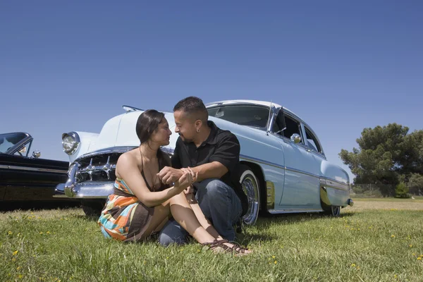 Hispanic couple in front of low rider car