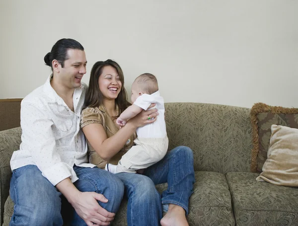 Asian parents smiling at baby