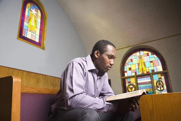 African American man reading Bible in church