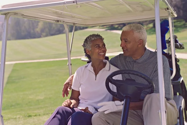Senior African American couple in golf cart