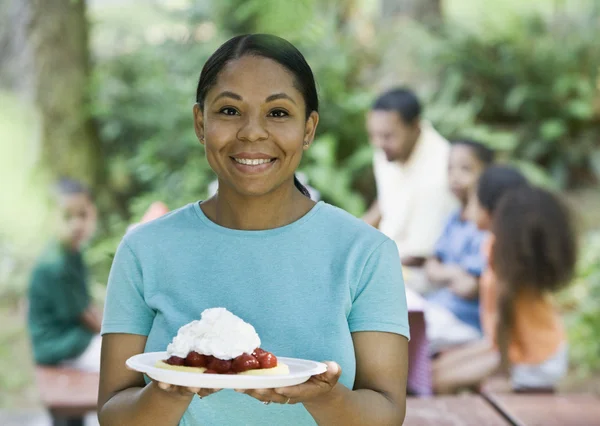 Mixed Race woman holding plate of dessert
