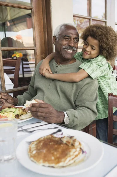 African American boy hugging grandfather