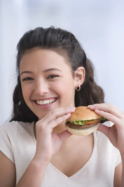 Hispanic girl eating hamburger