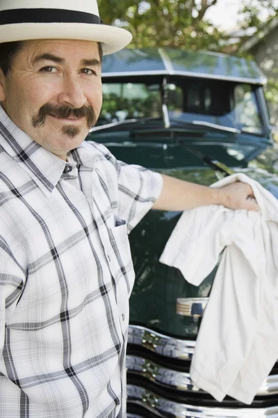 Hispanic man waxing truck
