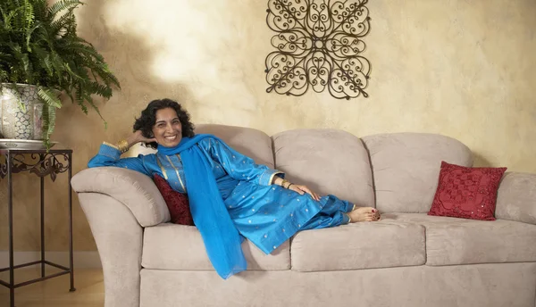 Indian woman sitting on sofa