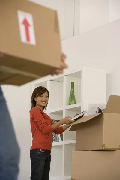 Asian woman packing moving boxes