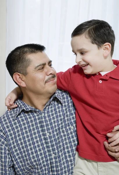 Hispanic father and son hugging