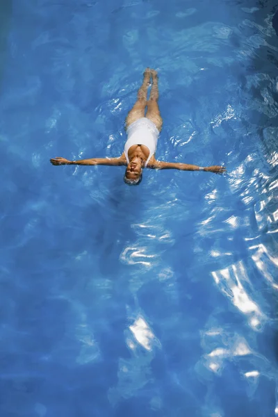 Senior woman floating in swimming pool