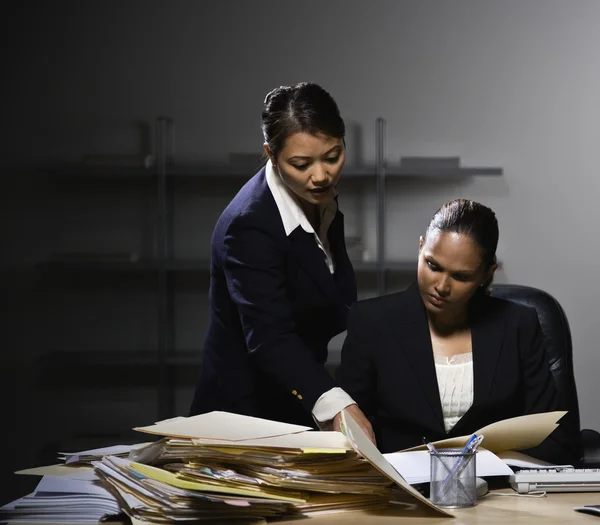Multi-ethnic businesswomen discussing paperwork