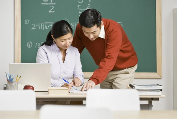 Asian teachers looking at paperwork