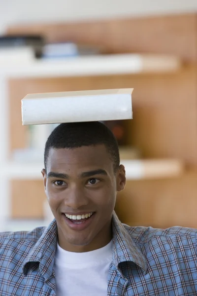 African man balancing book on head