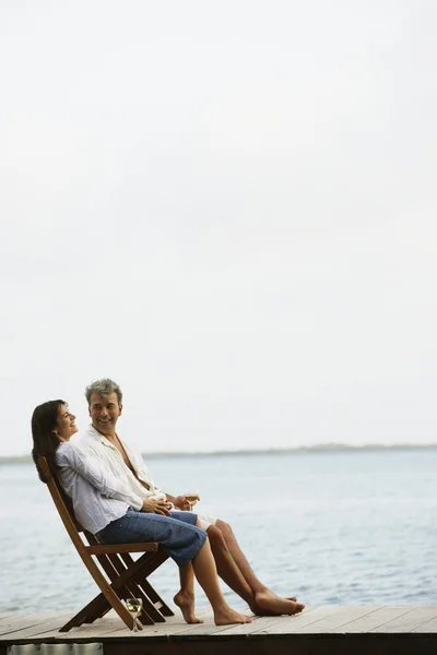 South American couple sitting on dock
