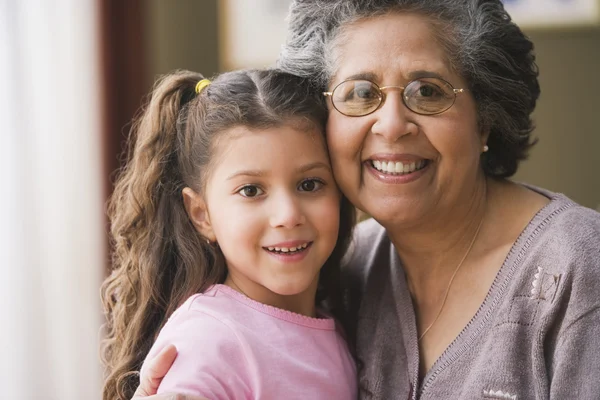 Hispanic grandmother hugging granddaughter