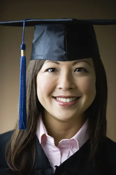 Asian woman wearing graduation cap and gown