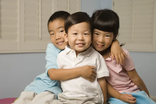 Asian siblings hugging