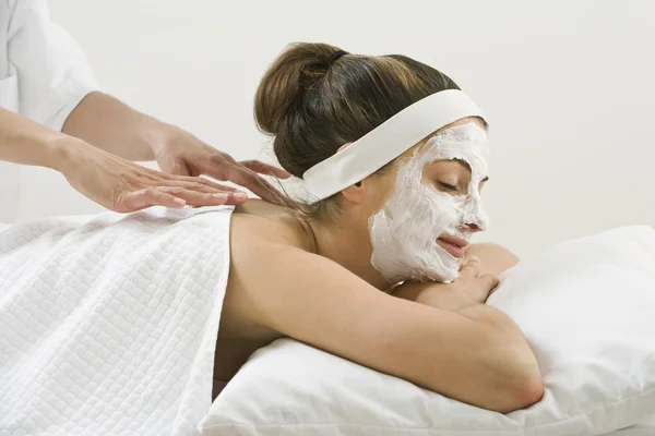 Woman receiving spa facial treatment