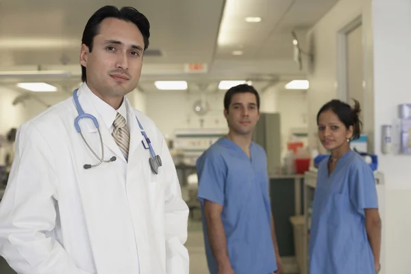 Hispanic male doctor with coworkers in background