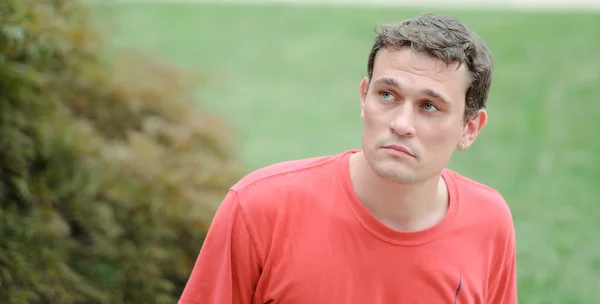 Pensive young man relaxing in a park