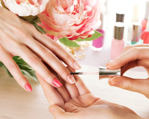 Woman applying nail varnish to finger nails