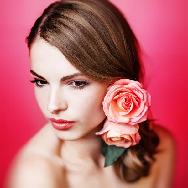 Pretty Young girl with pink roses in hair