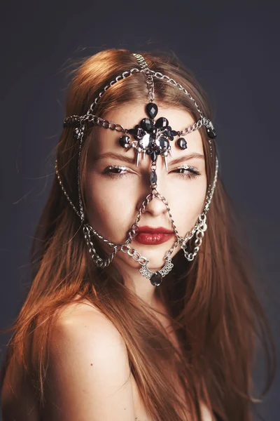 Young girl with chain mask
