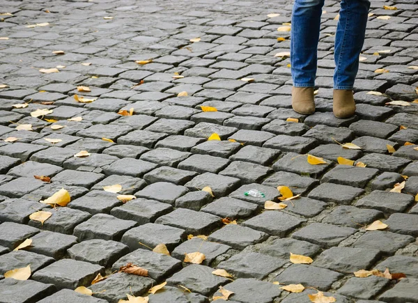 Female legs on Parisian cobblestone street
