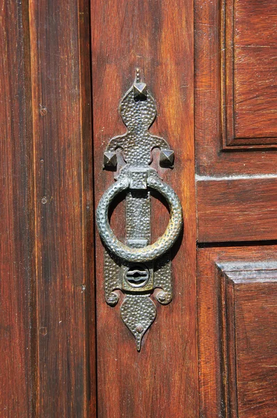 Castle gate doorknocker. Aged photo.